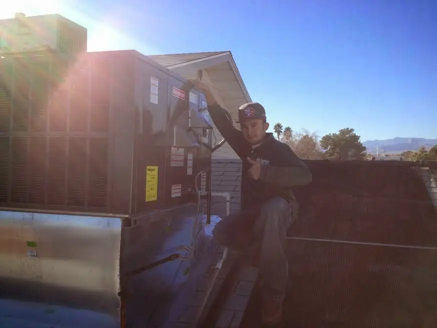 HVAC technician performing Heat Pump Repair on a rooftop unit in Colorado Springs